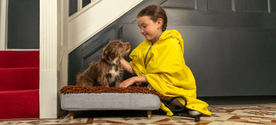 En flicka tittar på sin hund som ligger på hundsängen Topology från Omlet